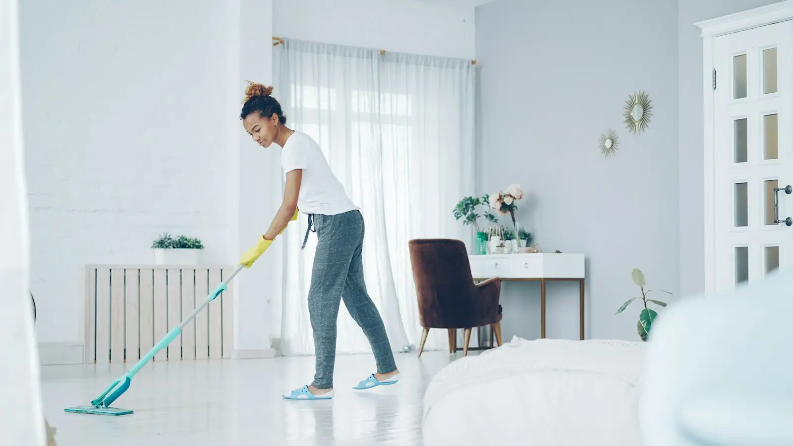 Person mopping the floor of a bright living room